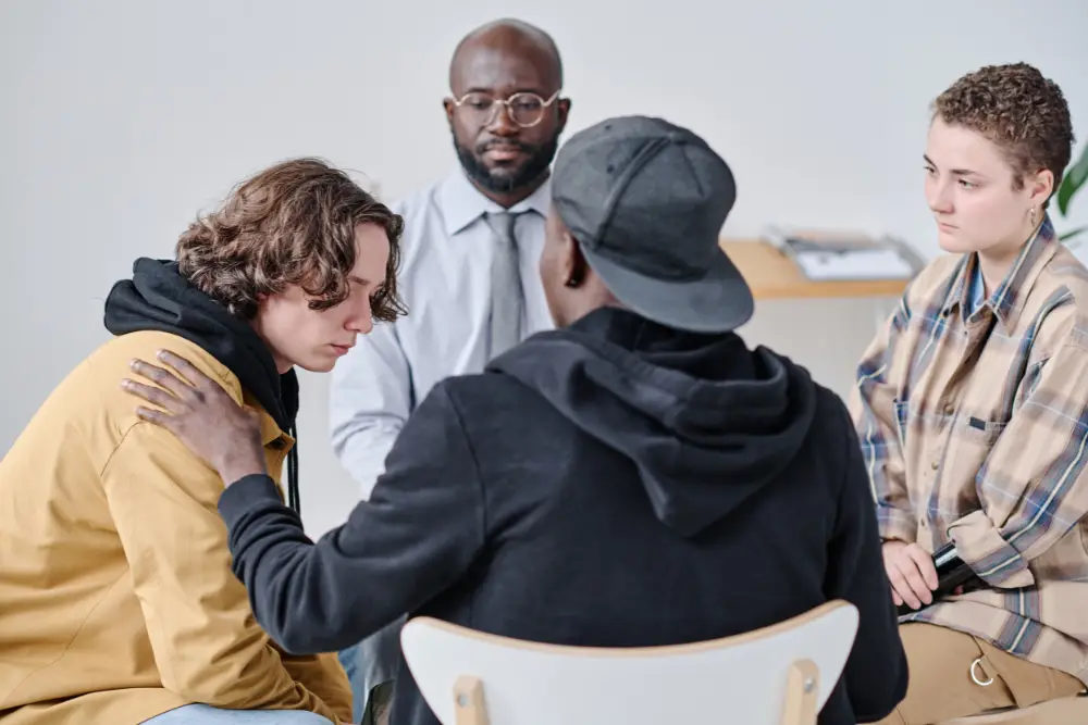 Young man receiving support during group therapy session, representing what to expect in outpatient rehab and the role of peer accountability.